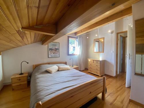 une chambre avec un lit et un plafond en bois dans l'établissement Les Angles - T4 Duplex 3 chambres - 6 pers, Parking, prox. commodités - FR-1-758-19, aux Angles