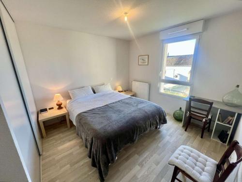 Schlafzimmer mit einem Bett, einem Schreibtisch und einem Fenster in der Unterkunft Appartement Étel, 2 pièces, 4 personnes - FR-1-479-155 in Étel