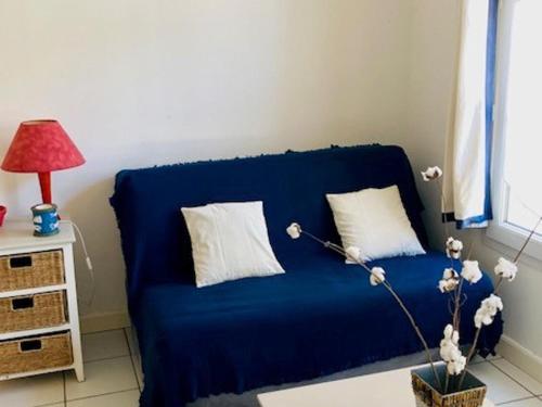 um sofá azul numa sala de estar com um candeeiro em Studio Saint-Martin-de-Ré, 2 pièces, 4 personnes - FR-1-544-25 em Saint-Martin-de-Ré