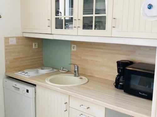 um balcão de cozinha com um lavatório e um micro-ondas em Studio Saint-Martin-de-Ré, 2 pièces, 4 personnes - FR-1-544-25 em Saint-Martin-de-Ré