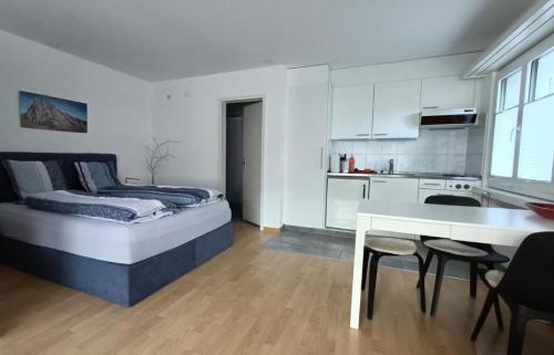 Cet appartement comprend une chambre avec un lit et une cuisine avec une table. dans l'établissement Ferienwohnung Falknis in Maienfeld mit Blick auf die Berge - b48844, à Maienfeld