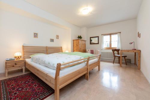 ein Schlafzimmer mit einem großen Bett und einem Schreibtisch in der Unterkunft Apartment Puntschella Veglia - b48821 in Pontresina