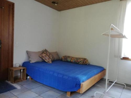 um quarto com uma cama azul num quarto em Casettina - b48822 em Minusio