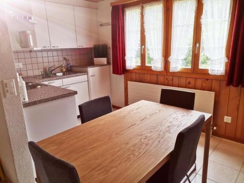cocina con mesa de madera y sillas en Neu eingerichtete Ferienwohnung im Haslital - b48815, en Innertkirchen