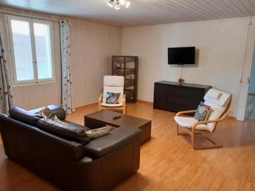 sala de estar con sofá, sillas y TV en Wohnung im Bauerhof - b48860 en Luins