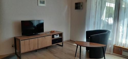 a living room with a television and a table and a chair at Rothorn-Center A 1OG- Schöpfer - b48829 in Sörenberg