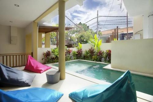 a house with a swimming pool and two pillows at Kuta Suci Guesthouse in Kuta