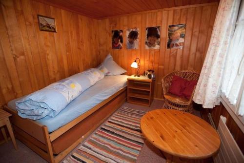 Dormitorio pequeño con cama y mesa en 45 Zimmer Ferienwohnung Hofstatthaus - b48818, en Hasliberg