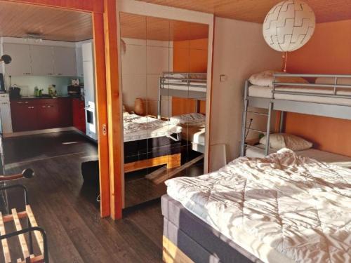 a room with two bunk beds and a kitchen at Rothorn-Center C direkt im Dorfzentrum - b48865 in Sörenberg