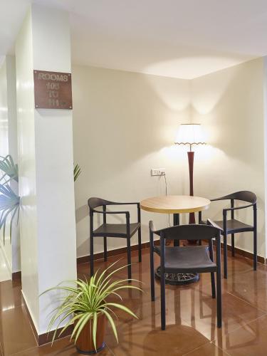 a table and chairs in a room with a table at Hotel Reemz in Chiplun