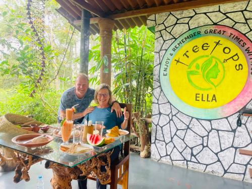 a man and woman sitting at a table at a restaurant at Treetops ella in Ella