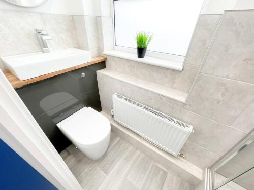 baño con aseo y lavabo y ventana en Stylish 4 Bedroom Apartment with Parking, en Bournemouth