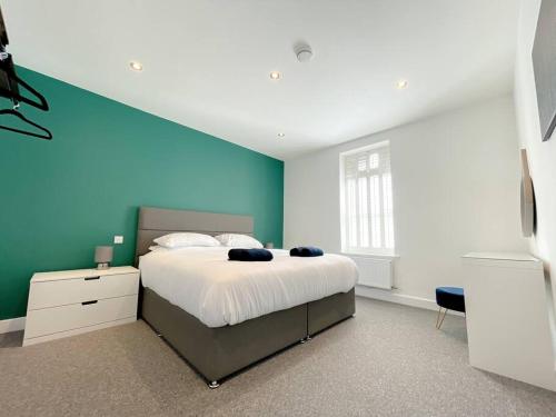 1 dormitorio con 1 cama grande y pared azul en Stylish 4 Bedroom Apartment with Parking, en Bournemouth