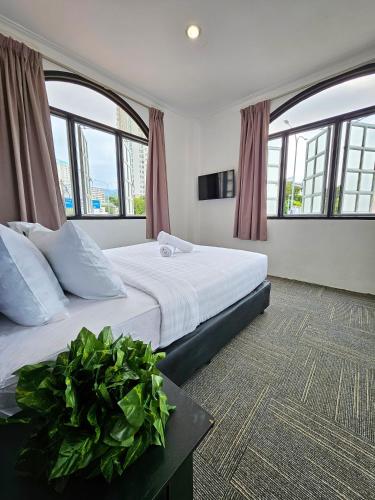 1 dormitorio con 2 camas y ventanas grandes en Luna Hotel by Moonknight en George Town