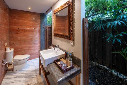 a bathroom with a sink and a toilet at Adiwana Svarga Loka - A Retreat Resort in Ubud