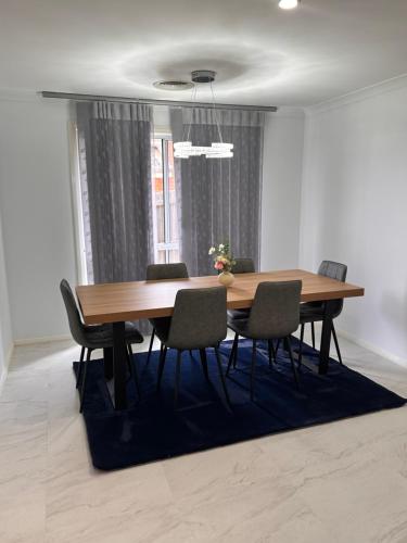a dining room with a wooden table and chairs at Canberra 3 Bedroom home to remember in Harrison