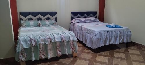 twee bedden naast elkaar in een kamer bij PARAISO in Puerto Callao