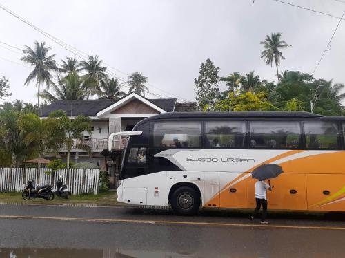 a person with an umbrella standing next to a bus at Sand 1 Hostel in Siquijor