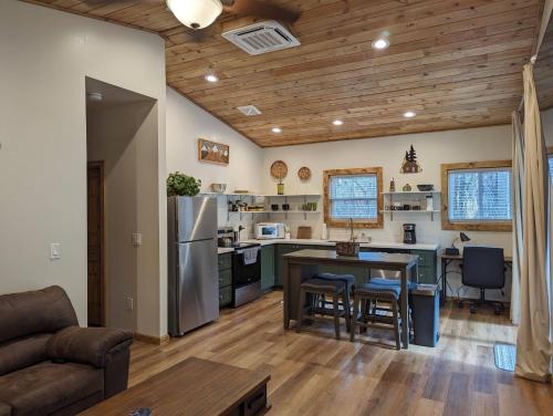 派托普湖畔的住宿－Cozy Cottage 2BD/2BA, 2 Covered Decks, Patio Dinning, Newly Built!，厨房以及带桌子和冰箱的客厅。