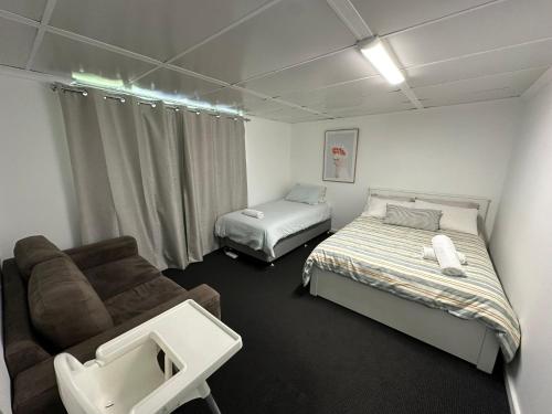 Cette chambre dispose d'un canapé, d'un lit et d'un canapé. dans l'établissement Peppermint Cottage, à Broadwater