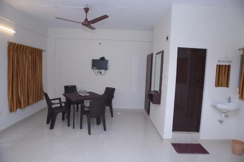 uma sala de jantar com uma mesa e cadeiras e um lavatório em Grand Pacific em Pondicherry