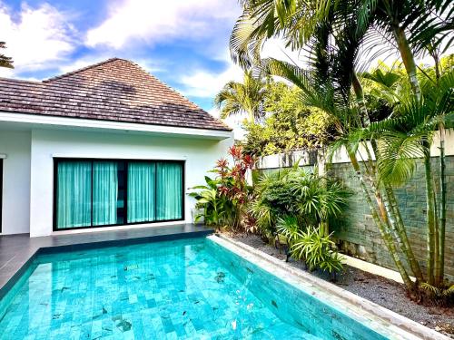 a swimming pool in front of a house at Villa Tara nr Layan Beach in Bang Tao Beach