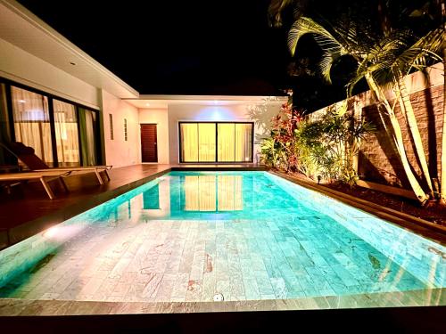 ein Schwimmbad in einem Haus in der Nacht in der Unterkunft Villa Tara nr Layan Beach in Ban Phru Champa