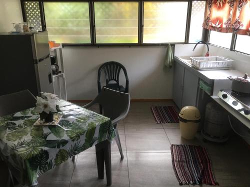 uma cozinha com uma mesa e uma mesa e cadeiras em Iaoraboraborahouse TEREIA em Bora Bora