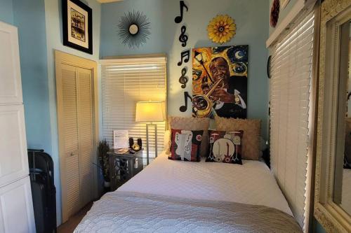 a bedroom with a bed with a poster on the wall at Jazzy Studio in a GREAT Location in New Orleans