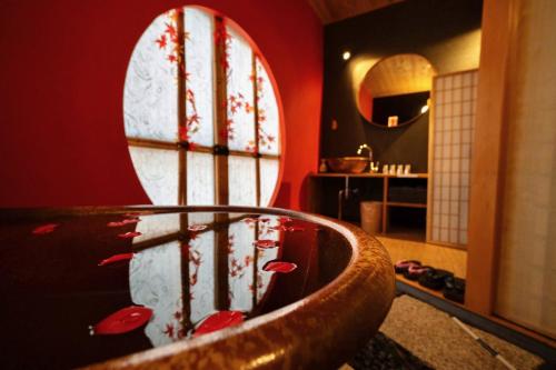 a bathroom with a tub with red walls and a mirror at ゼロイン祇園三条 in Kyoto