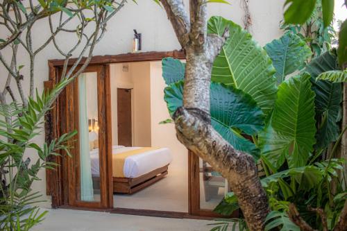 a bedroom with a mirror and a tree at Spicepeek Boutique Hotel CMB Airport in Katunayake