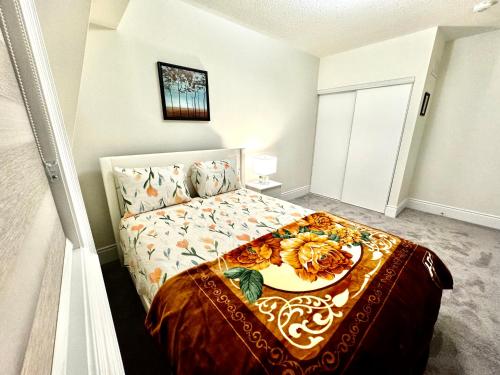 a bedroom with a bed with a floral blanket on it at C&M LUXURY HOME in Brampton