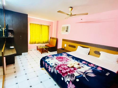 um quarto com uma cama com colcha floral em Hotel Vishal em Siliguri