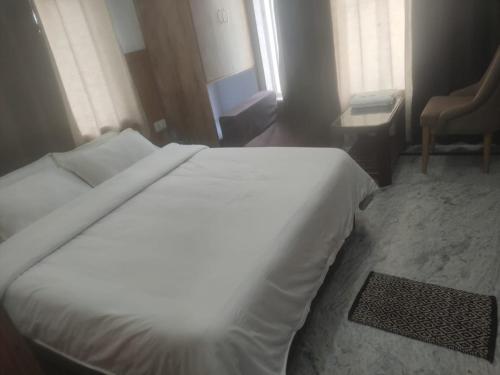 białe łóżko w pokoju z oknem w obiekcie Rishikesh by prithvi yatra hotels dharmshala w mieście Rishikesh