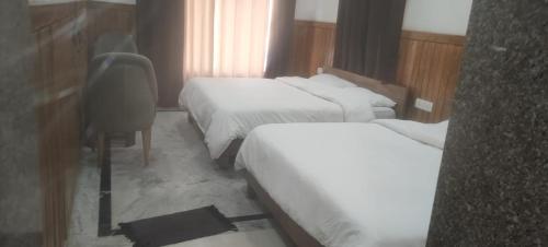 リシケーシュにあるRishikesh by prithvi yatra hotels dharmshalaのベッド2台とデスクが備わるホテルルームです。