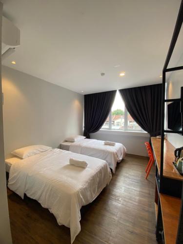 two beds in a room with two windows at Super 8 Hotel Alor Setar in Alor Setar