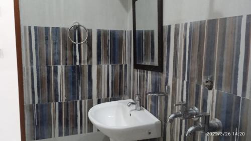 ein Bad mit einem Waschbecken und einem Spiegel in der Unterkunft Haridwar and kedarnath dharmshala in Haridwar
