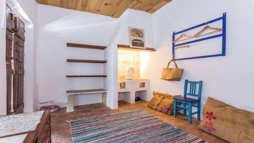 sala de estar con escalera y silla en Casa do Levante, en Olhão