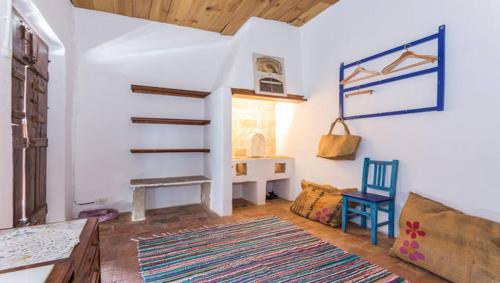 a living room with a staircase and a chair at Casa do Levante in Olhão