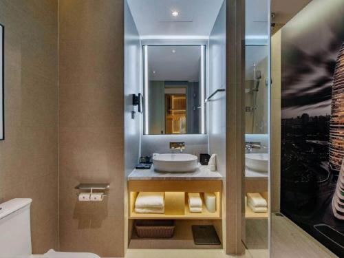 a bathroom with two sinks and a mirror at Park Inn by Radisson Chongqing Yuelai International Expo Center in Chongqing