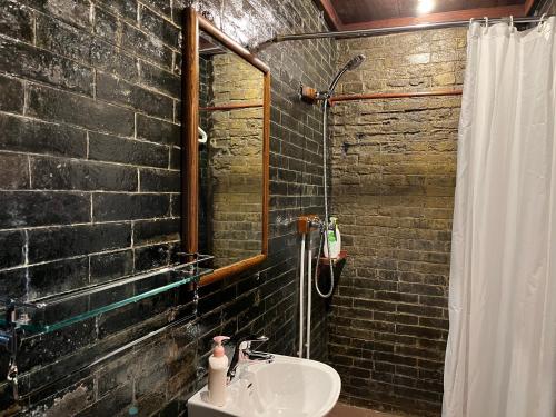 a bathroom with a sink and a brick wall at Pingyao Yide Hotel in Pingyao
