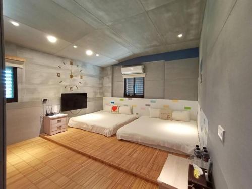 a bedroom with a large white bed and a flat screen tv at D3 Classic BNB in Wujie