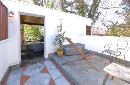 a patio with a bench and a table and chairs at 小さなホテルセラヴィ in Nagatoro