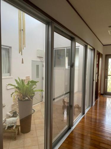 a sliding glass door in a living room with a potted plant at グリーンハウス in Nanjo
