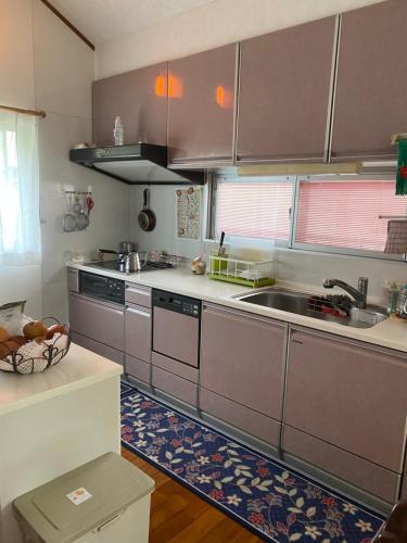 a kitchen with stainless steel cabinets and a sink at グリーンハウス in Nanjo