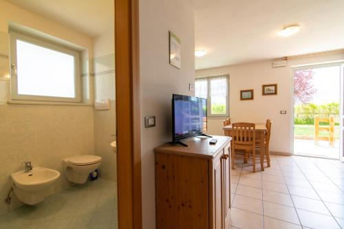 カヴァレーゼにあるAppartamenti Le Plejadiのバスルーム(トイレ付)、キャビネット内のテレビが備わります。