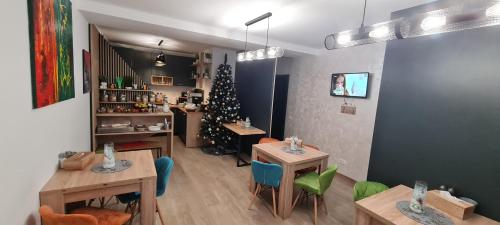 a restaurant with tables and a christmas tree in a room at Casa Pe Vale in Râşnov