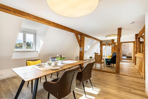 a dining room with a wooden table and chairs at Ferienwohnungen Metzgerpost in Altensteig