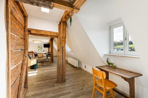 a living room with a wooden table and a window at Ferienwohnungen Metzgerpost in Altensteig