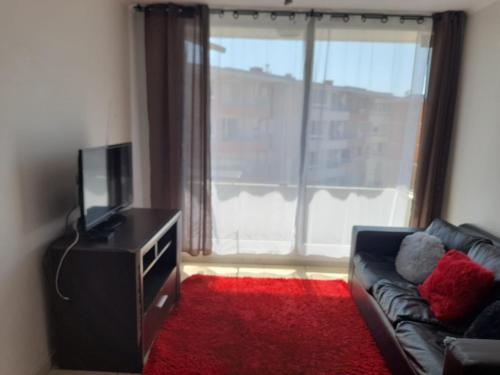 sala de estar con sofá y ventana grande en Departamente 2 habitaciones 2 baños a pasos playas supermercado y plaza de armas, en La Serena